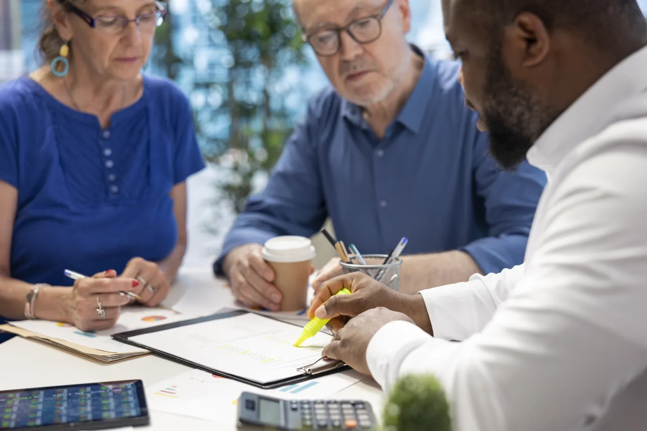 Advisers reviewing retirement fund documents around a table