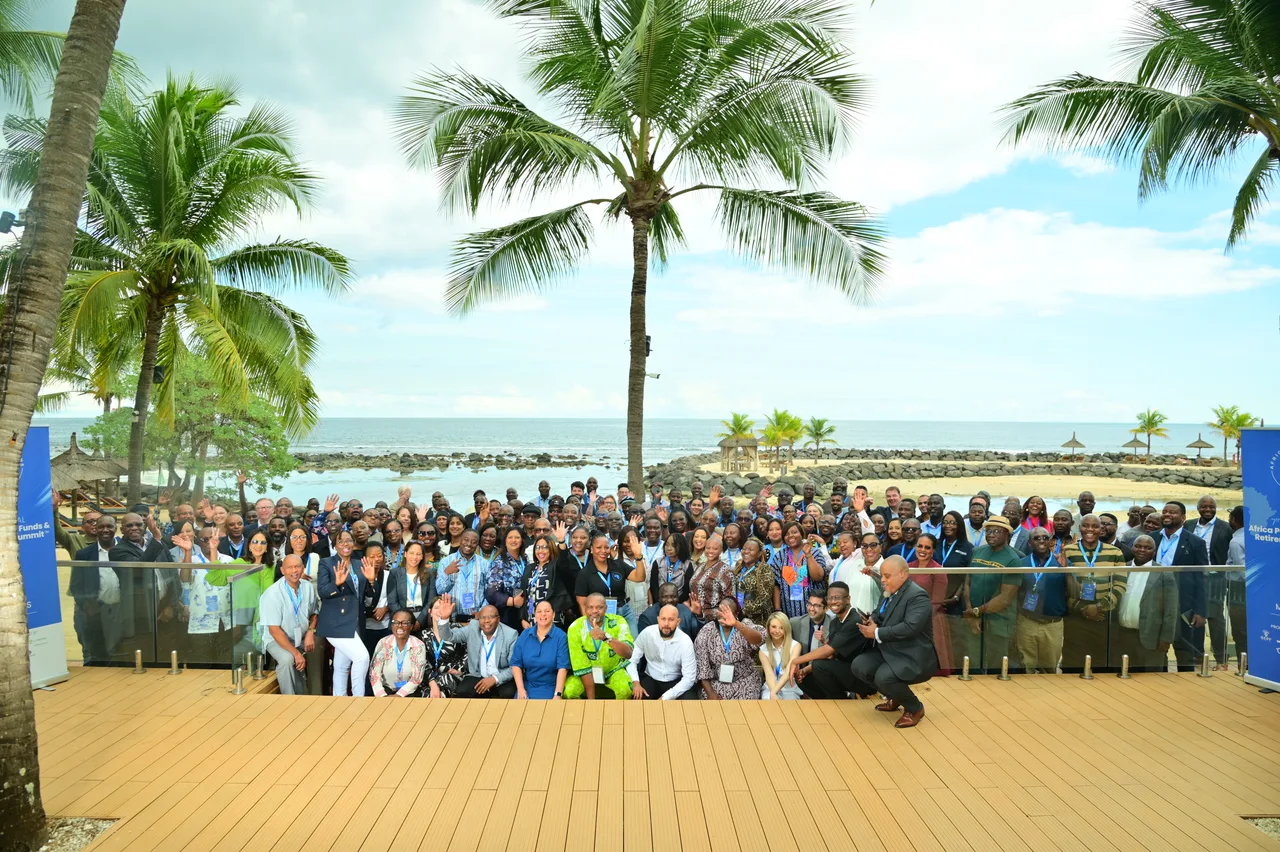 The 2026 delegation assembled on a beachfront deck beneath palm trees, Africa Pensions banners at either end