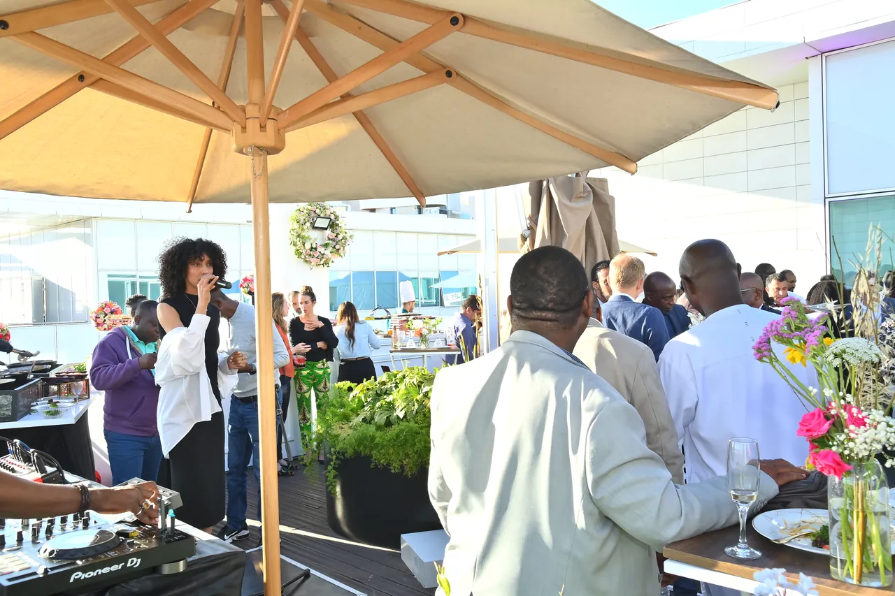 Delegates talking under parasols at an outdoor terrace reception