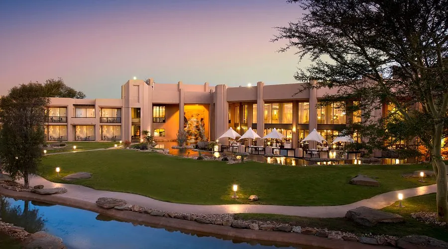 The Windhoek Country Club Resort at dusk, seen across its lawns and water gardens